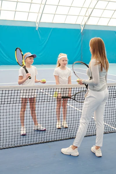 Zwei Glückliche Mädchen Mit Tennisschlägern Stehen Netz Vor Ihrem Trainer — Stockfoto