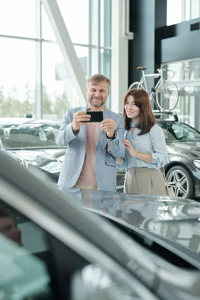 Homem Maduro Feliz Com Smartphone Tirando Foto Carro Novo Luxuoso — Fotografia de Stock