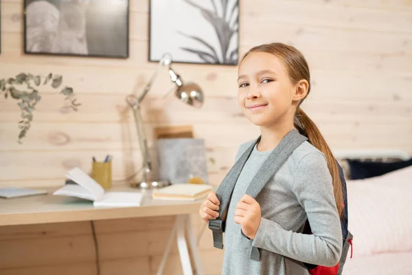 Contemporânea Colegial Feliz Com Mochila Frente Câmera Contra Sua Cama — Fotografia de Stock