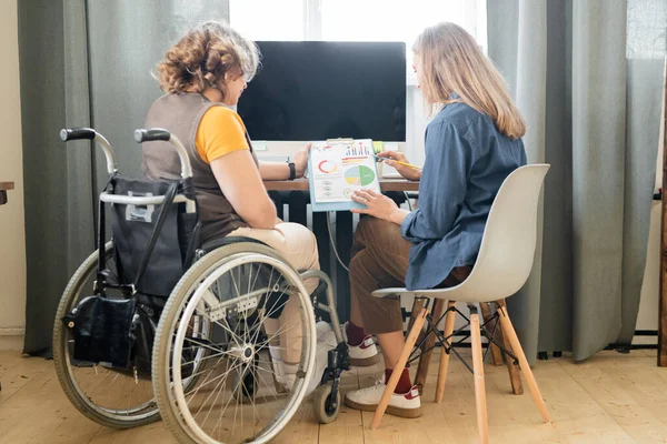 Twee Jonge Hedendaagse Vrouwelijke Kantoormedewerkers Discussiëren Financiële Documenten Met Grafieken — Stockfoto