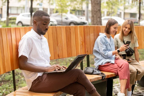 Allvarlig Afrikansk Kille Casualwear Sitter Bänk Park Och Nätverk Medan — Stockfoto