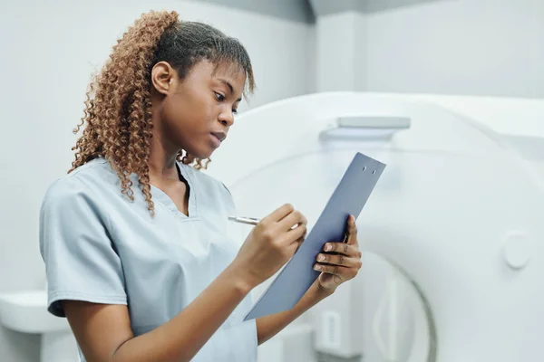 Pretty Nurse African Ethnicity Uniform Making Notes Medical Document While — Stock Photo, Image