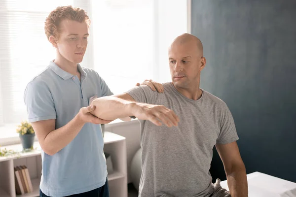 Physiotherapist Supporting Patient Arm Elbow While Consulting Helping Him Rehabilitation — Foto Stock