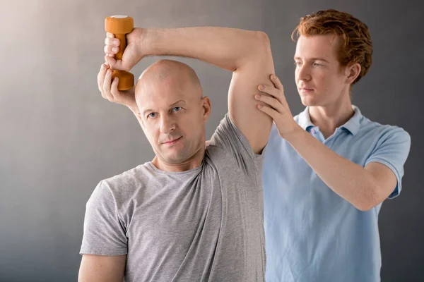Bald Muscular Man Grey Shirt Doing Exercise Dumbbell While Young — Fotografia de Stock