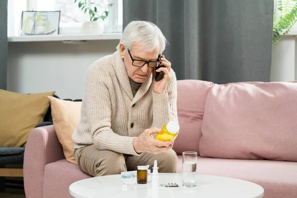 Hombre Mayor Ropa Casual Sentado Sofá Sosteniendo Botella Pastillas Consultar — Foto de Stock