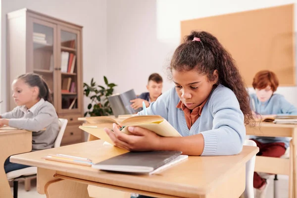 Smart Söt Skolflicka Läsa Bok Och Göra Anteckningar Vid Skrivbordet — Stockfoto