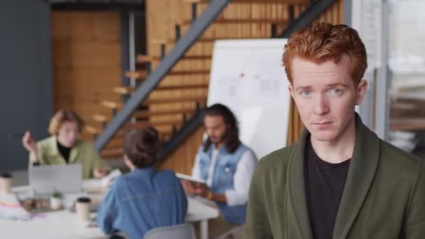 Modern Ofisin Toplantı Odasında Kameraya Gülümseyen Kızıl Saçlı Neşeli Genç — Stok video