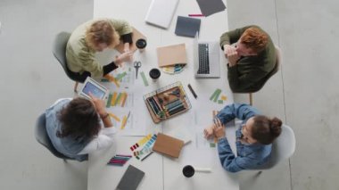 Tablet tutan genç erkek uygulama geliştiricisinin en iyi görüntüsü ve yeni proje için arayüz fikirlerini meslektaşlarımıza gösteriyor