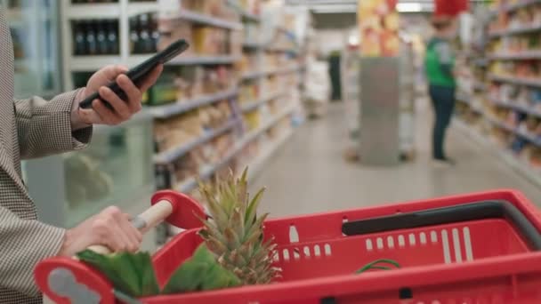 Hipermarkette Günlük Yiyecek Alışverişi Yaparken Elinde Meyveli Kırmızı Alışveriş Arabası — Stok video