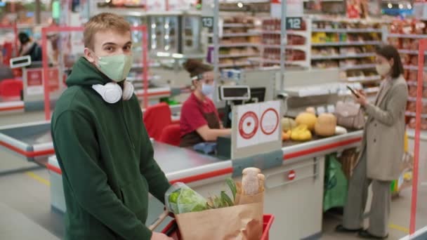 Ritratto Medio Ragazzo Con Cappuccio Verde Maschera Monouso Piedi Ipermercato — Video Stock