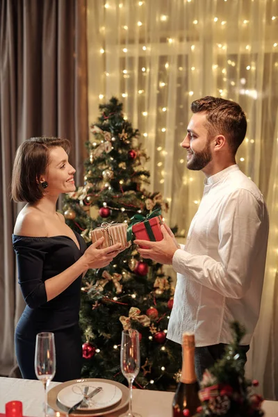 正の美しい若いカップルが反対側に立ってお互いに準備ができて交換クリスマスプレゼント — ストック写真