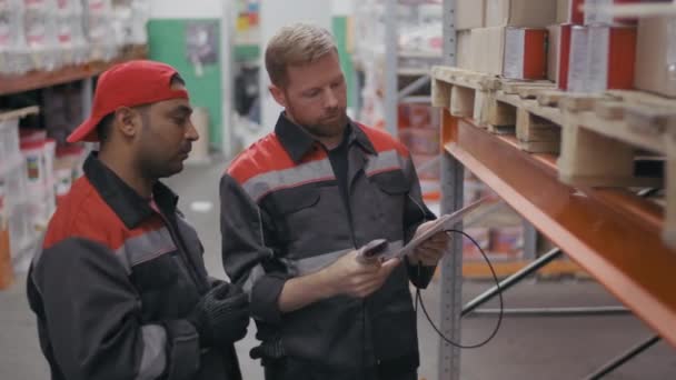 Mittlere Aufnahme Von Zwei Multiethnischen Lagerarbeitern Uniformanzügen Die Barcodes Auf — Stockvideo