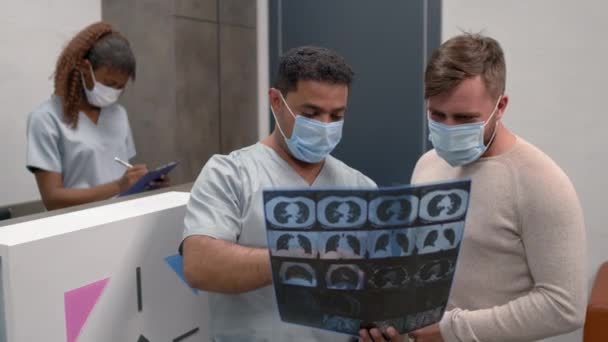 마스크를 의사와 환자의 주사는 병원의 리셉션 지역에서 촬영을 있습니다 — 비디오