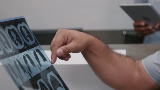 Ręczne Zbliżenie Zdjęcia Nierozpoznawalnego Radiologa Płci Męskiej Czytającego Tomografię Komputerową — Wideo stockowe