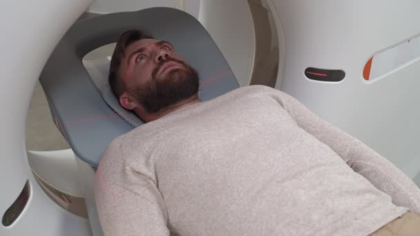 Średnie Ujęcie Brodatego Mężczyzny Leżącego Nieruchomo Kanapie Zabiegowej Wewnątrz Tomografii — Wideo stockowe