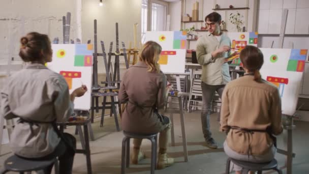 Parlak Sanat Atölyesinde Kadın Yetişkin Öğrencilerin Önünde Soyut Resim Ustası — Stok video