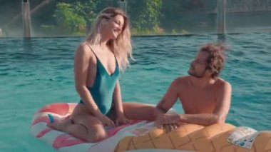 Su yatağında, havuzda, açık terasta flört eden genç çiftin tam karesi.