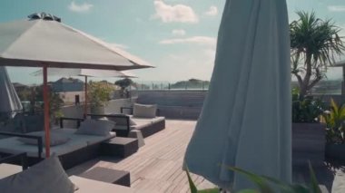 Şezlonglu ve şemsiyeli lüks otelin teras manzarası.