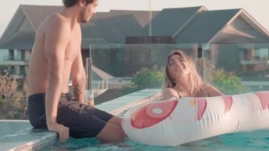 Tatilde eğlenen, flört eden ve yaz tatillerinin tadını çıkaran neşeli güzel çiftin orta boy fotoğrafı.