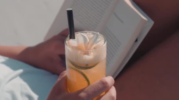 Detailní Záběr Papírové Knihy Ženských Rukou Smíšeným Pomerančovým Nápojem — Stock video