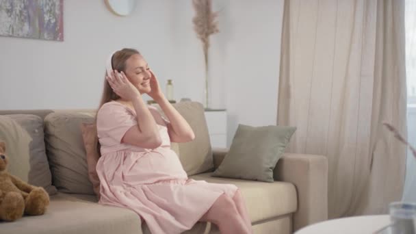 Orta Yavaş Çekimde Gülümseyen Hamile Kadın Evde Tek Başına Dinleniyor — Stok video