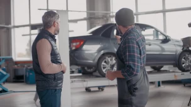 Handheld Seitenansicht Von Fröhlichen Männlichen Automechaniker Overalls Reden Und Schlüssel — Stockvideo