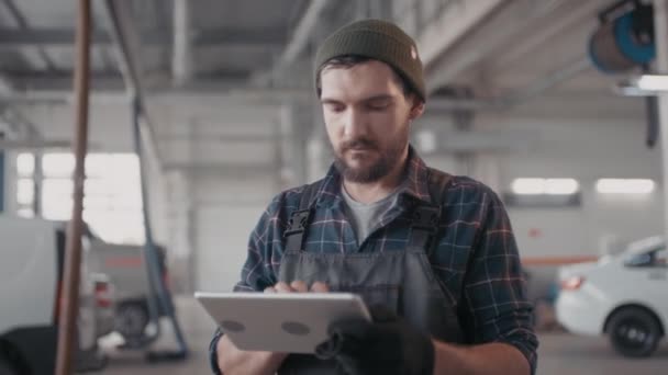 Garajda Müşterilerin Arabalarını Ederken Tulumuyla Tablete Yazarken Orta Boy Sakallı — Stok video