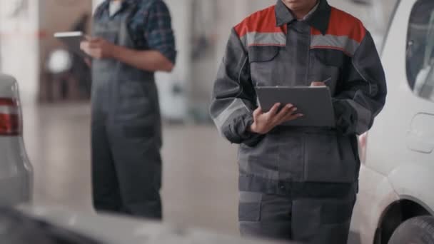 Schräge Aufnahme Einer Schwarzen Automechanikerin Die Notizen Auf Klemmbrett Schreibt — Stockvideo