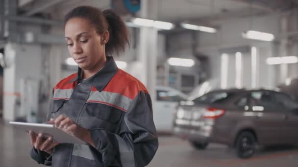 Pan Portrait Black Female Auto Mechanic Uniform Using Tablet While — Stock Video