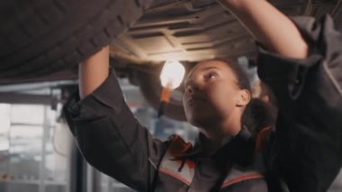 İngiliz anahtarı kullanarak ve arabanın bagajında tamirat yaparak siyah kadın otomobil tamircisine yakın çekim.