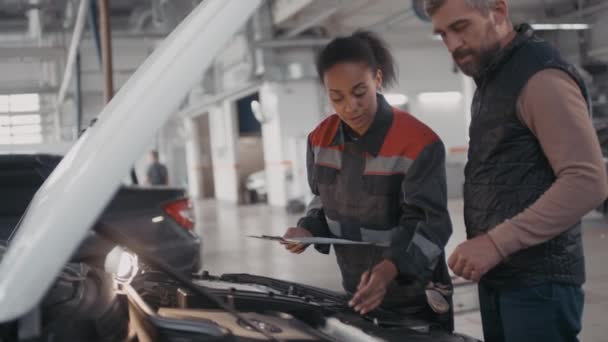 Slowmo Toma Mano Mujer Negra Mecánico Automóviles Uniforme Sujetando Portapapeles — Vídeos de Stock
