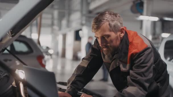 Handheld Shot Bearded Male Auto Mechanic Uniform Using Laptop Placed — Stock Video