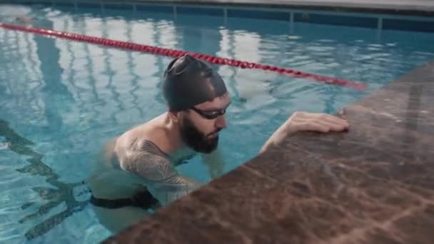 对戴着护目镜 头戴帽子 留着胡子的男子游泳运动员的慢镜头跟踪 — 图库视频影像