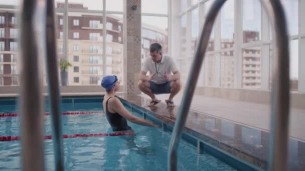 Langzame Tracking Van Vrouwelijke Zwemmer Die Het Zwembad Staat Luistert — Stockvideo