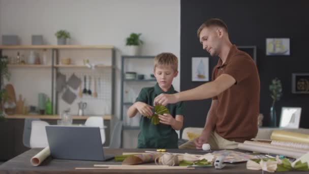 Medium Skott Unga Kaukasiska Pojke Leker Med Grönt Papper Båge — Stockvideo