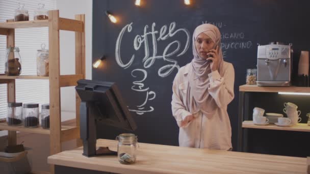 Közepes Felvétel Koncentrált Női Muszlim Kávéárusról Aki Komoly Telefonbeszélgetést Folytat — Stock videók