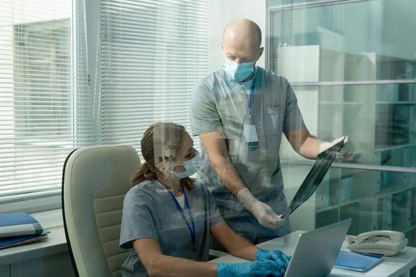 Jovem Médica Vestuário Trabalho Proteção Sentada Mesa Frente Laptop Olhando — Fotografia de Stock