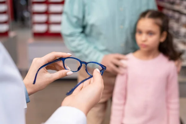 화이트 코트를 의사의 할아버지와 방문하는 귀여운 소녀에게 새로운 안경을 — 스톡 사진