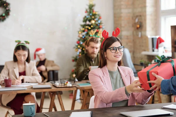 Happy Young Brunette Female Manager Xmas Headband Taking Packed Giftbox — Stock Photo, Image