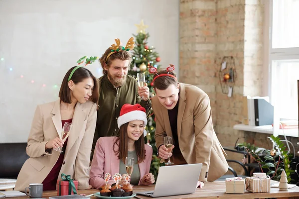 매니저들이 사무실에서 열리는 크리스마스 파티에서 노트북 화면을 건배와 행사를 있습니다 — 스톡 사진
