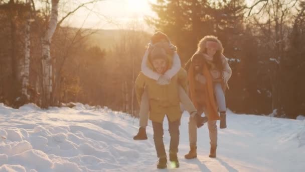 Média Lentidão Tiro Dois Casais Divertindo Correndo Caminho Nevado Mulheres — Vídeo de Stock