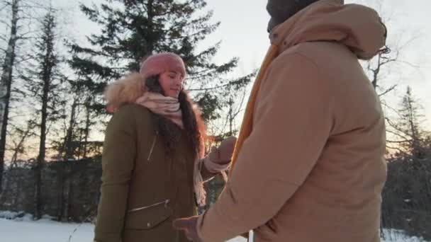 Alacsony Szögű Lassított Felvételű Többnemzetiségű Fiatal Pár Akik Hóesős Erdőben — Stock videók