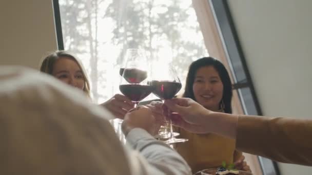 2日間で陽気な多民族の人々の中低速映像ファッショナブルなレストランで楽しい時間を過ごす赤ワインのクリンクグラス — ストック動画