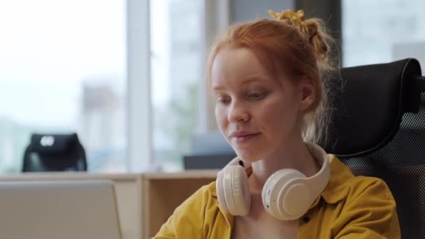 Großaufnahme Eines Lächelnden Rothaarigen Mädchens Das Großraumbüro Arbeitet Kopfhörer Trägt — Stockvideo