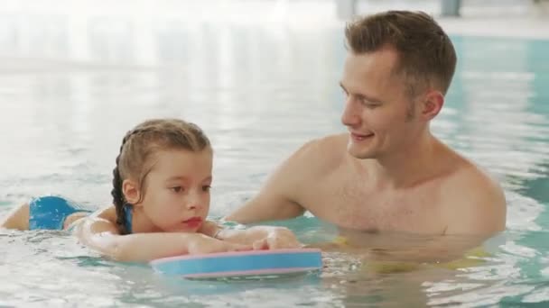 남자가 물에서 수영하는 소녀를 가르치는 슬로우 클로즈업 — 비디오