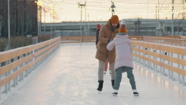 겨울에 시니어 부부가 스케이트장에서 딸에게 아이스 스케이팅을 가르치는 — 비디오