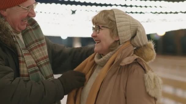 スカーフと彼の妻の帽子を調整するために暖かく保つために — ストック動画