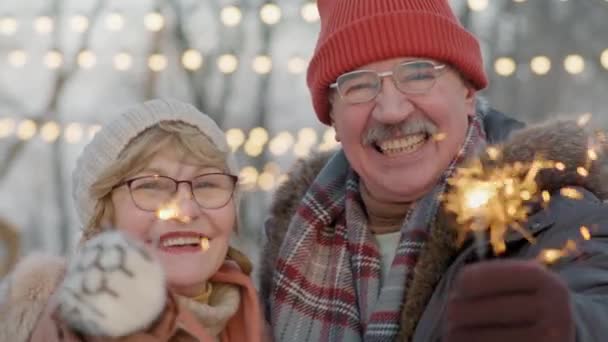 Zbliżenie Portret Uśmiechniętej Pary Seniorów Trzymającej Iskry Lodowisku Świeżym Powietrzu — Wideo stockowe
