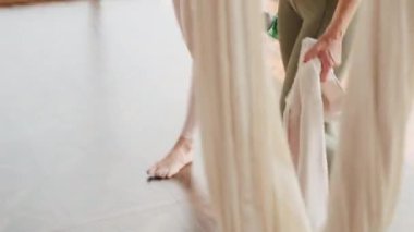 Eğitimden önce panoramik pencerelerle parlak ve ferah yoga stüdyosunda yürürken sıkı spor giyim giymiş iki genç kadının orta boy yakın çekim görüntüleri.