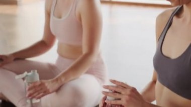 Aero yoga dersinden sonra stüdyoda poz verip su içen Kafkas kadınlarının yakın çekimleri.